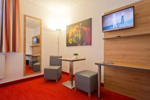 a room with a table and two chairs and a mirror at City Hotel in Chemnitz