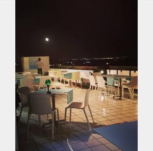 eine Person, die auf einem Dach mit Tischen und Stühlen steht in der Unterkunft Hotel Intervallo in Torre Lapillo
