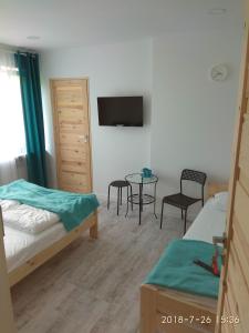 a bedroom with two beds and a table and a tv at Na Kwiatkowskiego in Sandomierz