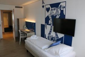 a room with a bed and a tv on a wall at Aparthotel Paderborn in Paderborn