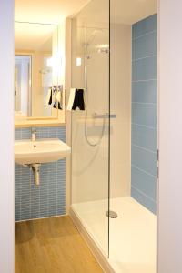 a bathroom with a shower and a sink at IBB Hotel Paderborn in Paderborn