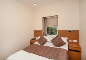 1 dormitorio con 2 camas y ventana en NOX Olympia, en Londres