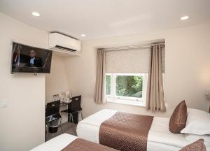 um quarto de hotel com duas camas e uma televisão em NOX Olympia em Londres
