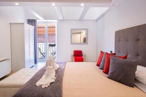 Hotel Rivoli Sorrento في سورينتو: غرفة نوم بسرير كبير عليها حشره محشوة