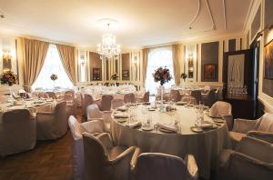 a banquet room with tables and chairs and a chandelier at Baltic Star Villas in Petergof