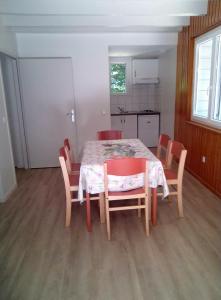 a dining room with a table and chairs and a kitchen at La Truite in Saint-Amans-Valtoret