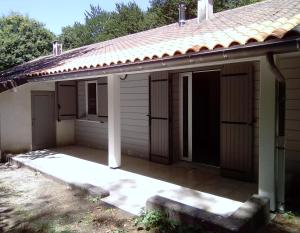 a porch of a house with a roof at La Truite in Saint-Amans-Valtoret