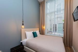 a bedroom with a bed and a large window at Stadsvilla Mout Rotterdam-Schiedam in Schiedam