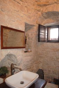 La salle de bains est pourvue d'un lavabo et d'une fenêtre. dans l'établissement Trulli Aria di Casa, à Alberobello