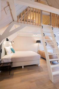 a bedroom with a bed and a staircase at Stadsvilla Mout Rotterdam-Schiedam in Schiedam