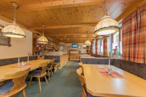 a dining room with wooden tables and chairs at Pension Rieder in Leogang