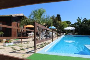 a pool at a resort with tables and umbrellas at Casa Janet in Cassibile