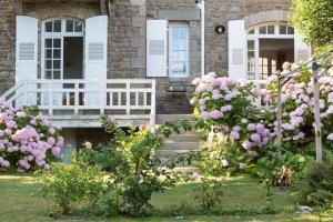 una casa con flores rosas delante de ella en Le Safran by Cocoonr, en Dinard