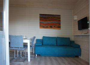 a living room with a blue couch and a table at Uzenabow in Wicie +28 photos