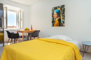 sypialnia z żółtym łóżkiem i stołem w obiekcie Dominium Old City Suite w Dubrowniku