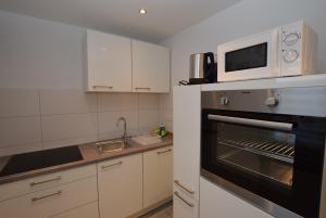 een keuken met een magnetron en een oven bij AB Apartment Objekt 109 in Ludwigsburg