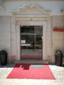 a red rug in front of a building at Hostel Rossio Alcobaça in Alcobaça