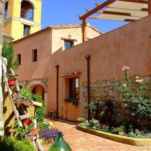 Un bâtiment avec un bouquet de fleurs devant lui dans l'établissement B&B Sa Specula IUN 4404, à San Vito