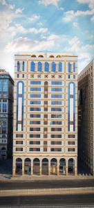duży budynek z niebieskimi oknami w mieście w obiekcie Odst Al Madinah Hotel w Medynie