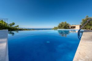 una piscina de agua azul en una casa en Ilyessa Cottages, en Méson Yerakaríon