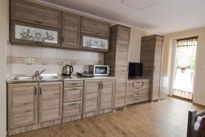 a kitchen with wooden cabinets and a sink at Cuha-gyöngye Apartmanház in Zirc