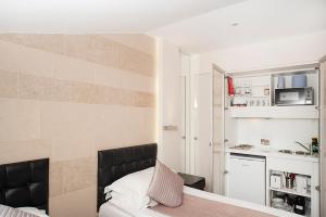 a small room with a bed and a microwave at NOX Kensington in London