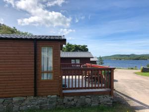 a cabin with a porch and a deck at West Loch Shores in Tarbert