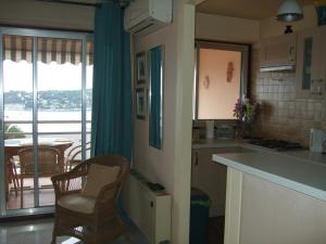 a kitchen with a counter and chairs and a balcony at L'Agrianthe in Villefranche-sur-Mer