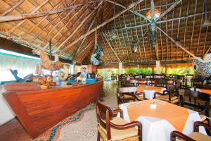a restaurant with tables and chairs and a bar at Casa del Mar Cozumel Hotel & Dive Resort with free access to an exclusive beach club in Cozumel