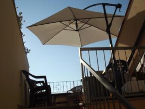 una sombrilla blanca en la parte superior de un balcón en Casa Elena, en Cala Gonone