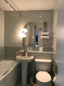 La salle de bains est pourvue de toilettes, d'un lavabo et d'une baignoire. dans l'établissement Inverkip Hotel, à Inverkip