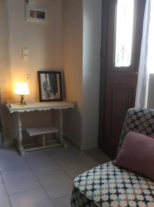 een woonkamer met een tafel, een lamp en een stoel bij Villa Eleni in Lithínai