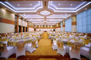 un gran salón de banquetes con mesas y sillas blancas en Atria Hotel Magelang, en Magelang
