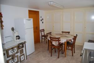 a kitchen with a table and chairs and a white refrigerator at Gîtes Le Tokay et Le Muscat in Gertwiller