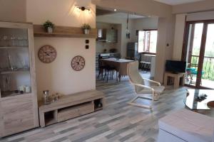 a living room with a clock on a wall at Villa Sofia in Marathos