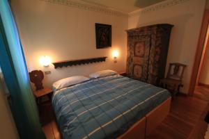 a bedroom with a blue bed with two pillows at Casa Elisa in Pozza di Fassa