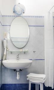 a bathroom with a sink and a mirror at Hotel Pupetto in Positano