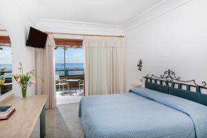 a bedroom with a blue bed and a view of the ocean at Hotel Pupetto in Positano +37 photos