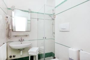 a white bathroom with a sink and a shower at Hotel Pupetto in Positano