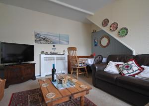 a living room with a couch and a table at Sunnieside Cottage in Seahouses