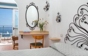 1 dormitorio con cama, espejo y balcón en Hotel Pupetto, en Positano