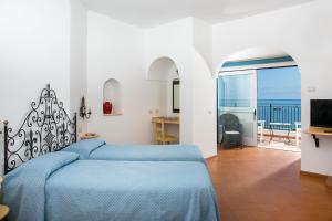 a bedroom with a bed and a view of the ocean at Hotel Pupetto in Positano