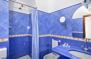 a blue bathroom with a toilet and a sink at Hotel Pupetto in Positano
