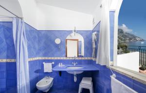 a blue bathroom with a sink and a mirror at Hotel Pupetto in Positano