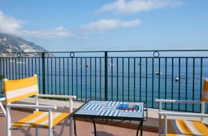 a balcony with two chairs and a table and the ocean at Hotel Pupetto in Positano