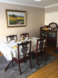 塔拉特的住宿－Clarendon，餐桌、椅子和墙上的绘画