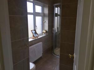 un bagno con doccia, WC e finestra di Clarendon a Tallaght