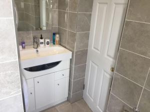 a bathroom with a white sink and a shower at Clarendon in Tallaght