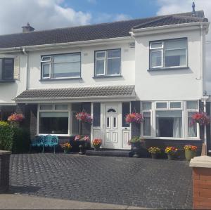 una casa bianca con due sedie davanti di Clarendon a Tallaght