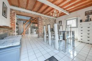 a kitchen with a glass table and a brick wall at Gîtes Casalé Di Vito in Longvilliers